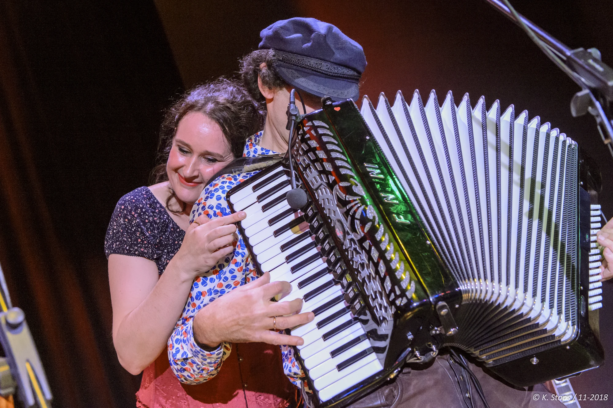 David en een medemuzikant delen een moment met de accordeon op het podium
